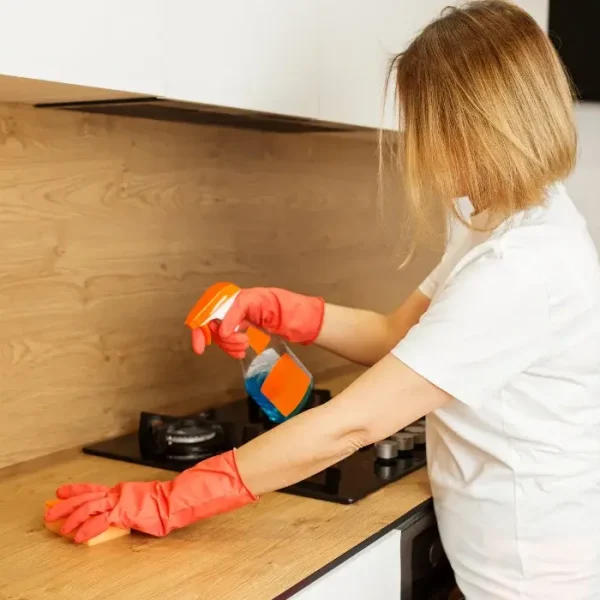 Woman-Cleaning-Kitchen-Countertop-with-Spray Woman-Cleaning-Kitchen-Countertop-with-Spray
